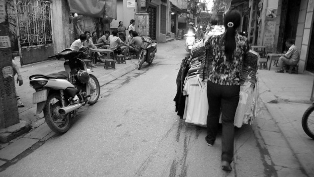 woman rolls shirt cart down street.jpg